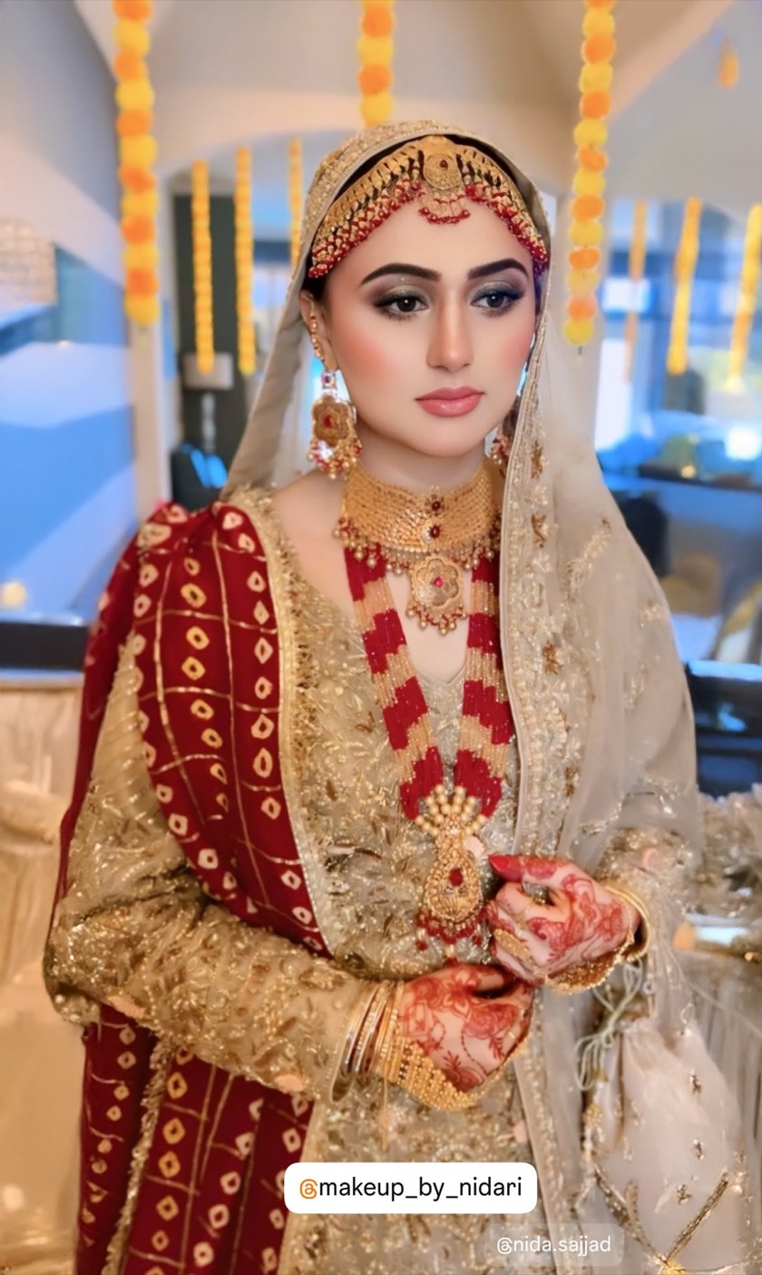 Traditional bridal glam with marigold garland backdrop by Makeup by Nidari, Houston